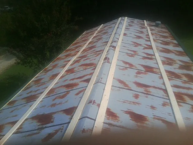 Rusted metal roof panels with new wood purlins before replacement — Storm Damage Roof Repair in Minden City by Roofing Brothers