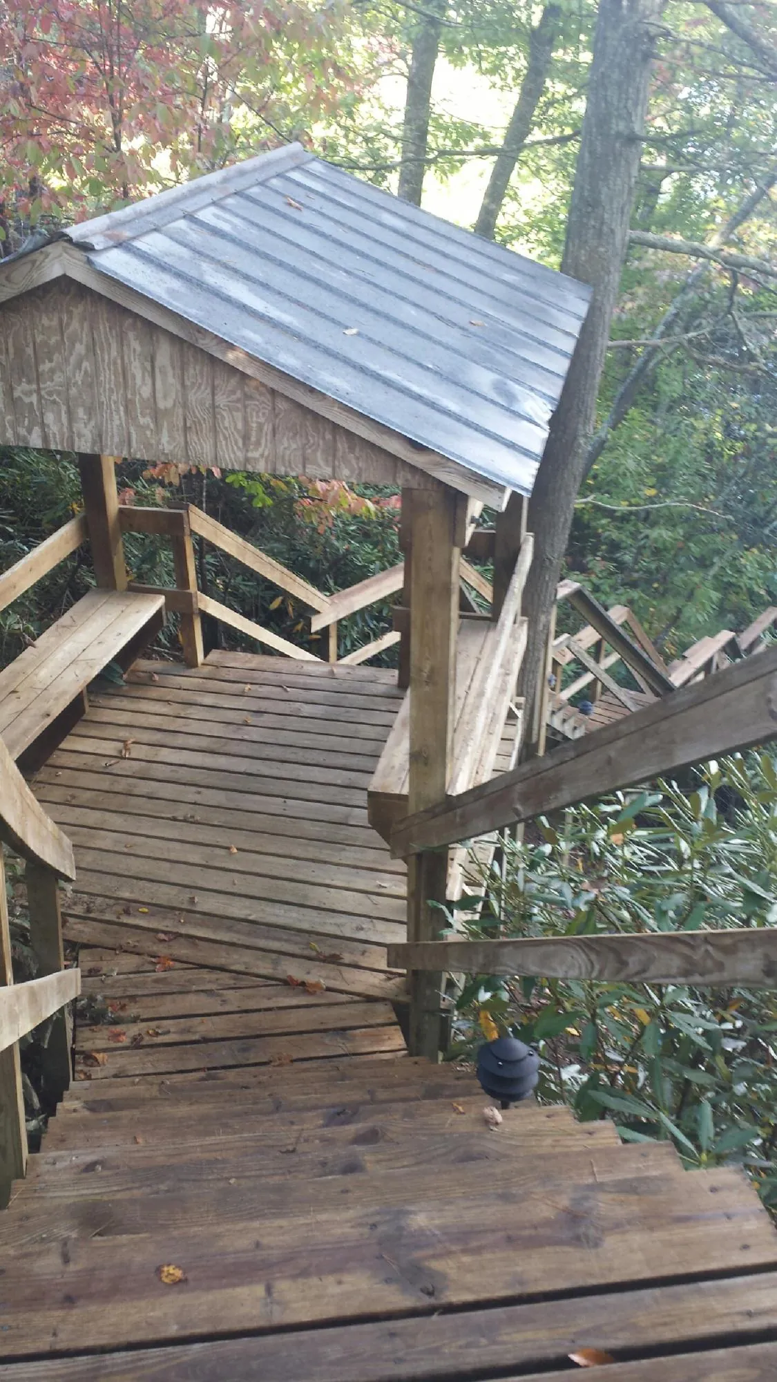 Metal roofed shelter over wooden steps on a wooded walkway — Skylight Repair & Installation work by our crew in Minden City