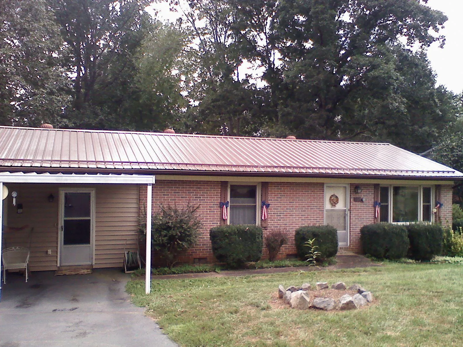 Bronze metal roof and carport on a brick ranch home — Roof Repair work by our crew in Minden City