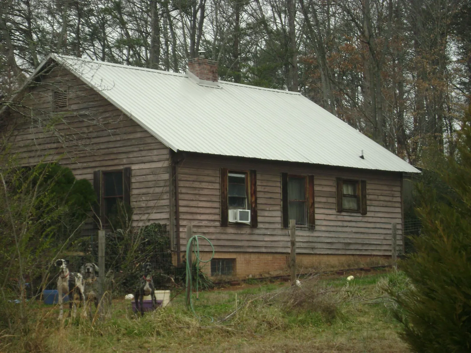 White metal roof on an old wood sided farmhouse, from a Metal Roof Installation job in Minden City
